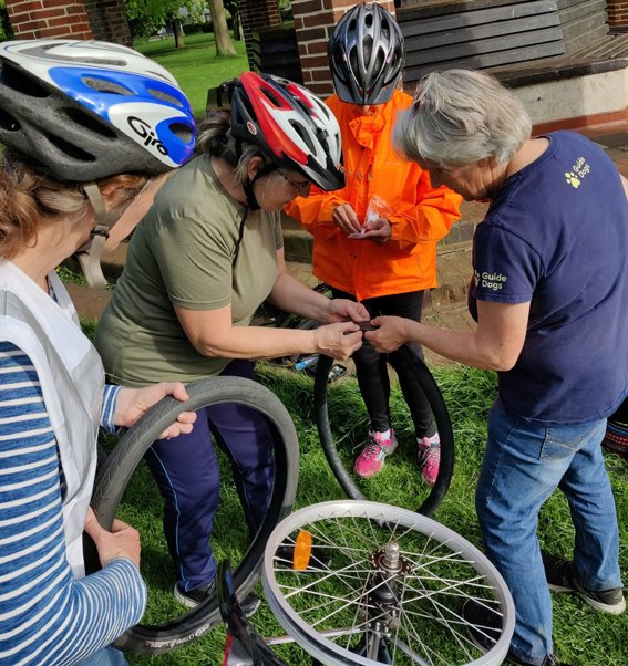 Group of women mending a bicycle puncture as part of JoyRiders training