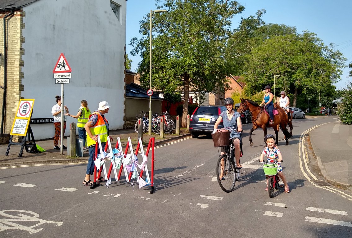 School Streets signs closing road to traffic with mother and child cycling