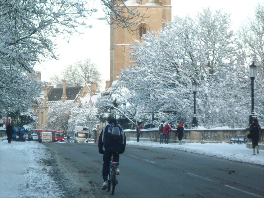 Cyclist on Magdalen Bridge Oxford in snow. Credit Tejvan Pettinger