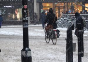 Cyclist on compacted snow in Broad Street, Oxford, winter 2018