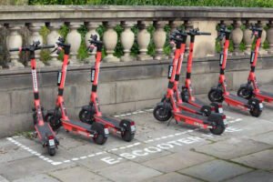 Pink e-scooters parked in marked bay on pavement in Oxford