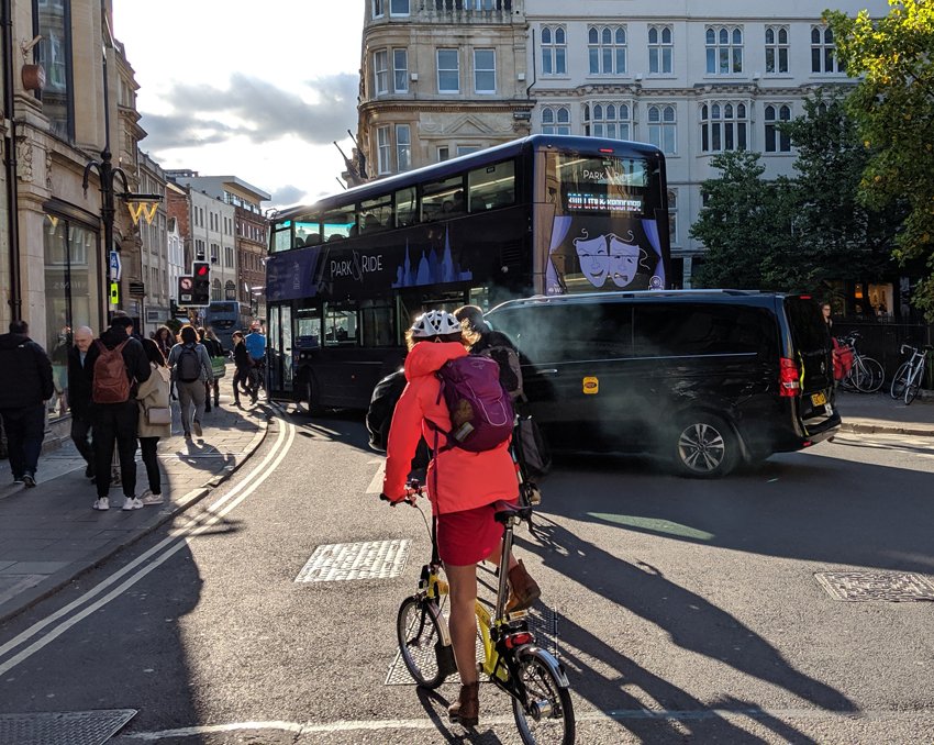 Cyclist and buses at junction of Broad Street and Cornmarket, Oxford