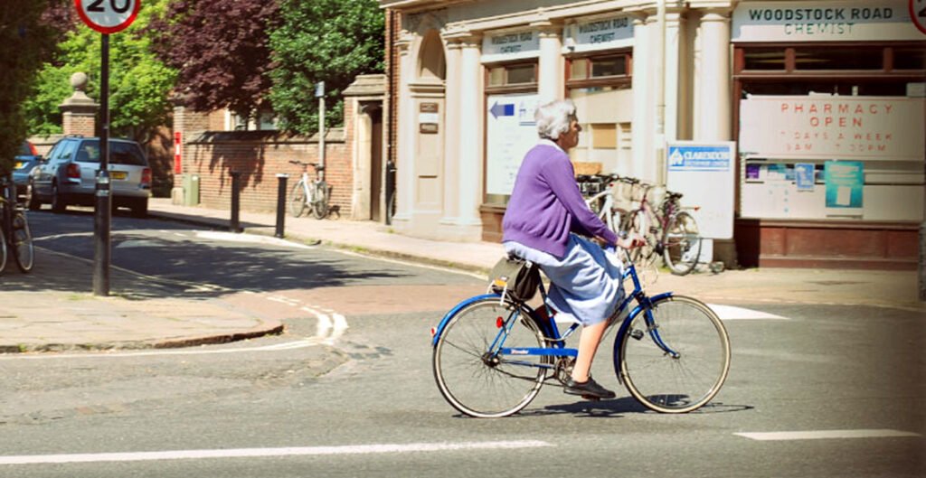 Older woman cycling in Woodstock Road, Oxford