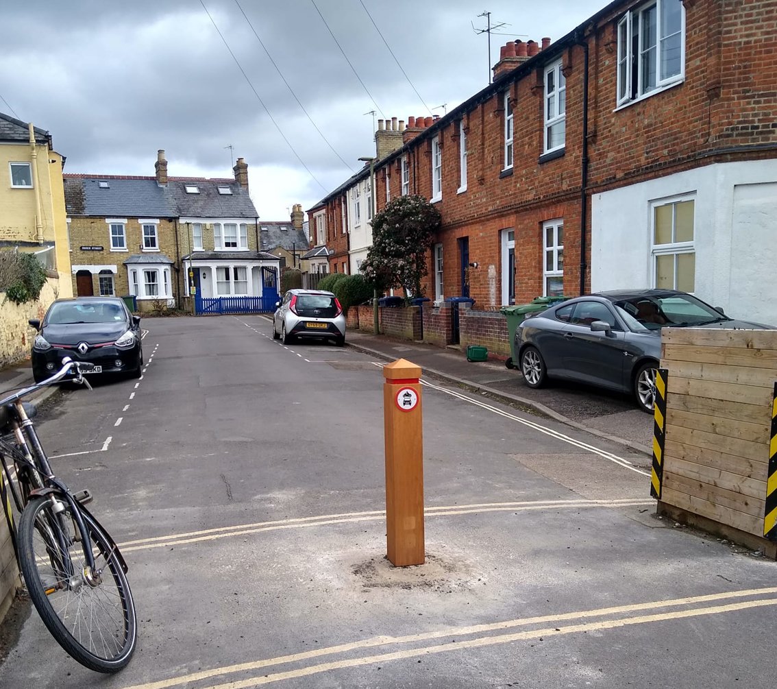 Road with a wooden bollard preventing cars driving through