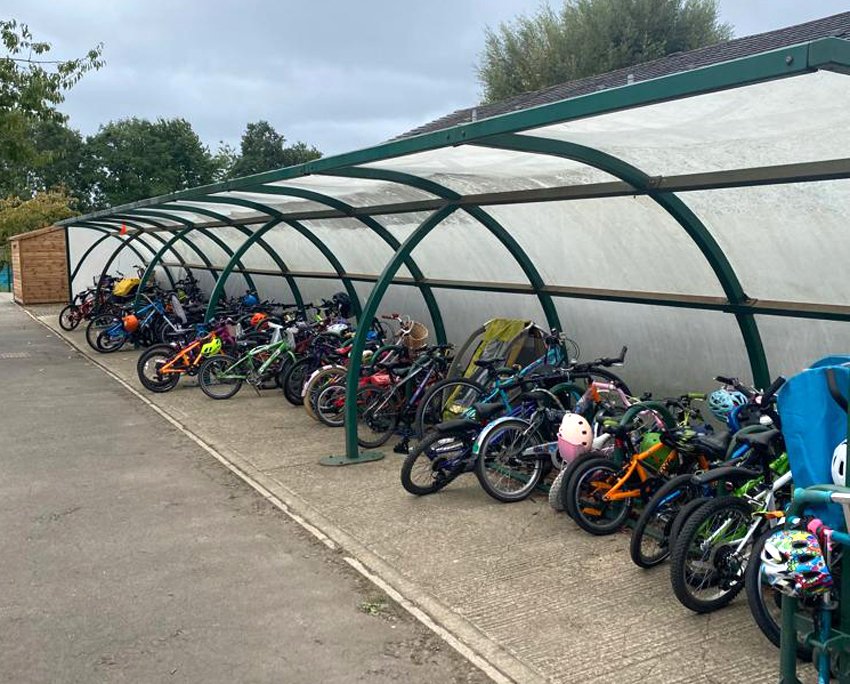 Covered cycle rack in primary school full of locked-up kids' bikes