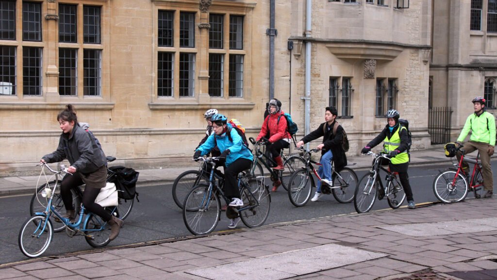 Street in Oxford with stream of cyclists travelling along it