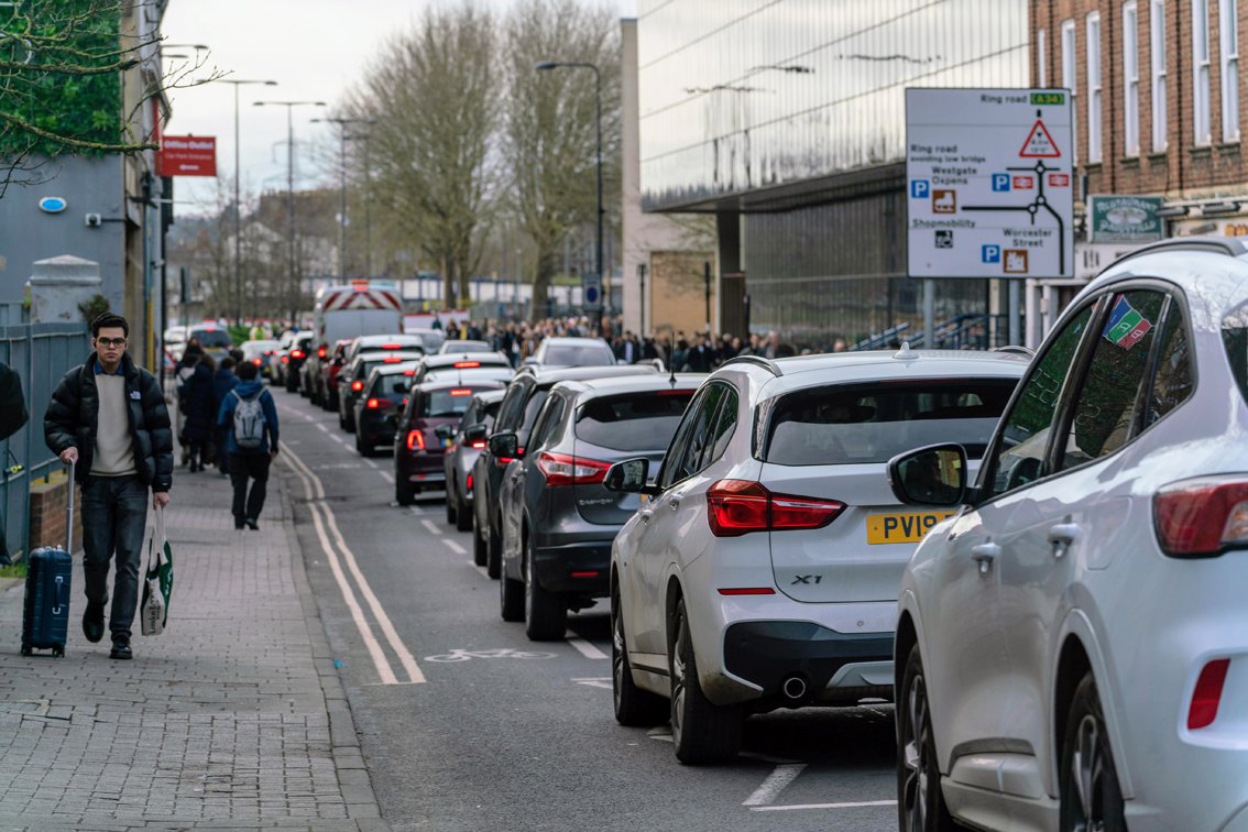 Hythe Bridge Street in Oxford with queue of cars heading west nose to tail. Pedestrians in large numbers on the pavements