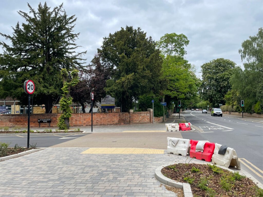Side road opening on to Woodstock Road with new layout and buff pedestrian crossing
