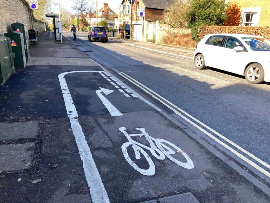 Cycle path on pavement with white arrow showing bikes must move on to road